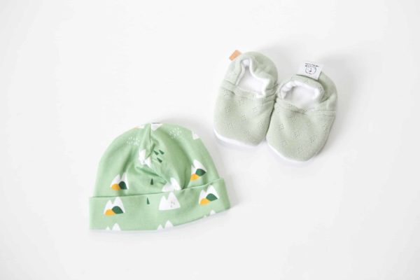 Coffret naissance comprenant une paire de chaussons vertes et un bonnet tissu montagne