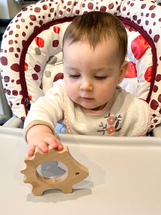 Bébé qui joue avec un anneau de dentition en bois